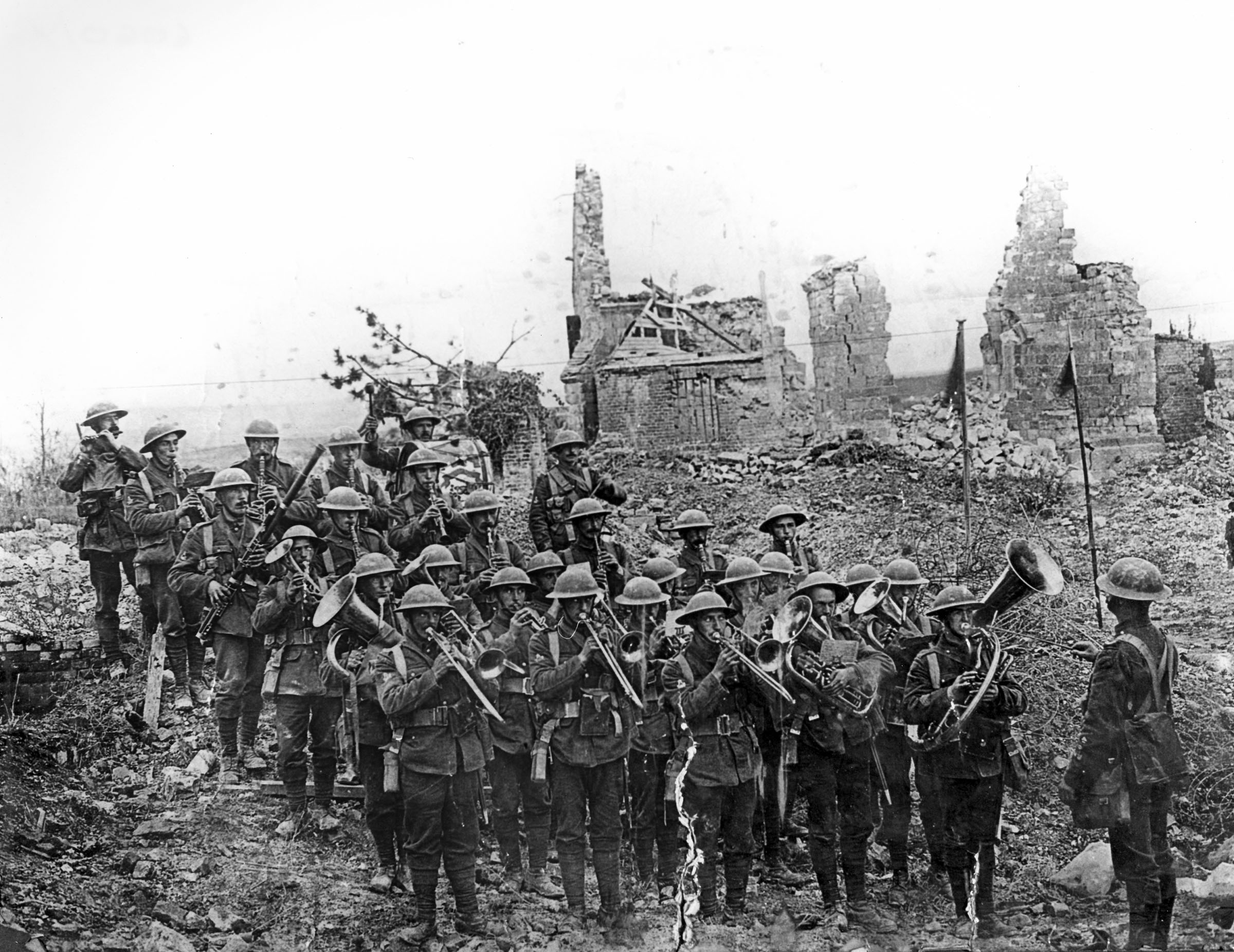 Photograph of the Band of the 5th Battalion, South Staffordshire Regiment, playing in the ruins at Ypres, Belgium, during the Great War